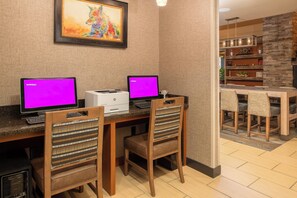 A modern kitchen with two laptops on a wooden table, a printer, and a framed painting on the wall. - Residence Inn by Marriott Helena (Helena)