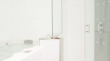 A modern bathroom with a glass-enclosed shower, a separate bathtub, and a wooden bench.