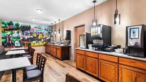 A restaurant with wooden cabinets, a counter with coffee machines, and a mural on the wall. - Best Western Halito Inn (Calera)