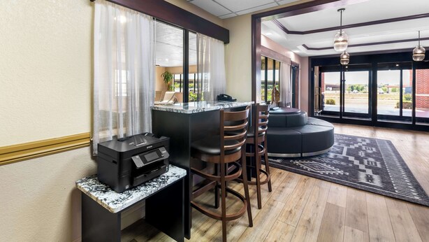 A hotel lobby with a reception desk, bar area, seating, and large windows offering a view. - Best Western Halito Inn (Calera)