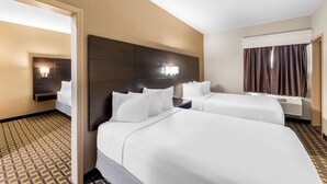 A hotel room with two beds, a headboard, bedside lamps, a window with curtains, and a patterned carpet. - Best Western Halito Inn (Calera)