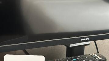 A non-smoking sign and a Philips monitor on a desk.