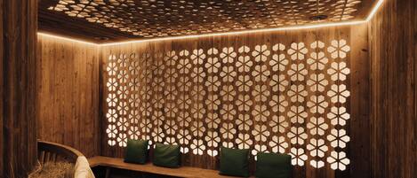 Un intérieur en bois avec un banc et un mur orné de motifs.