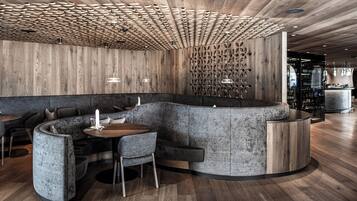 A modern interior with a curved seating area, wooden ceiling, and a bar counter.