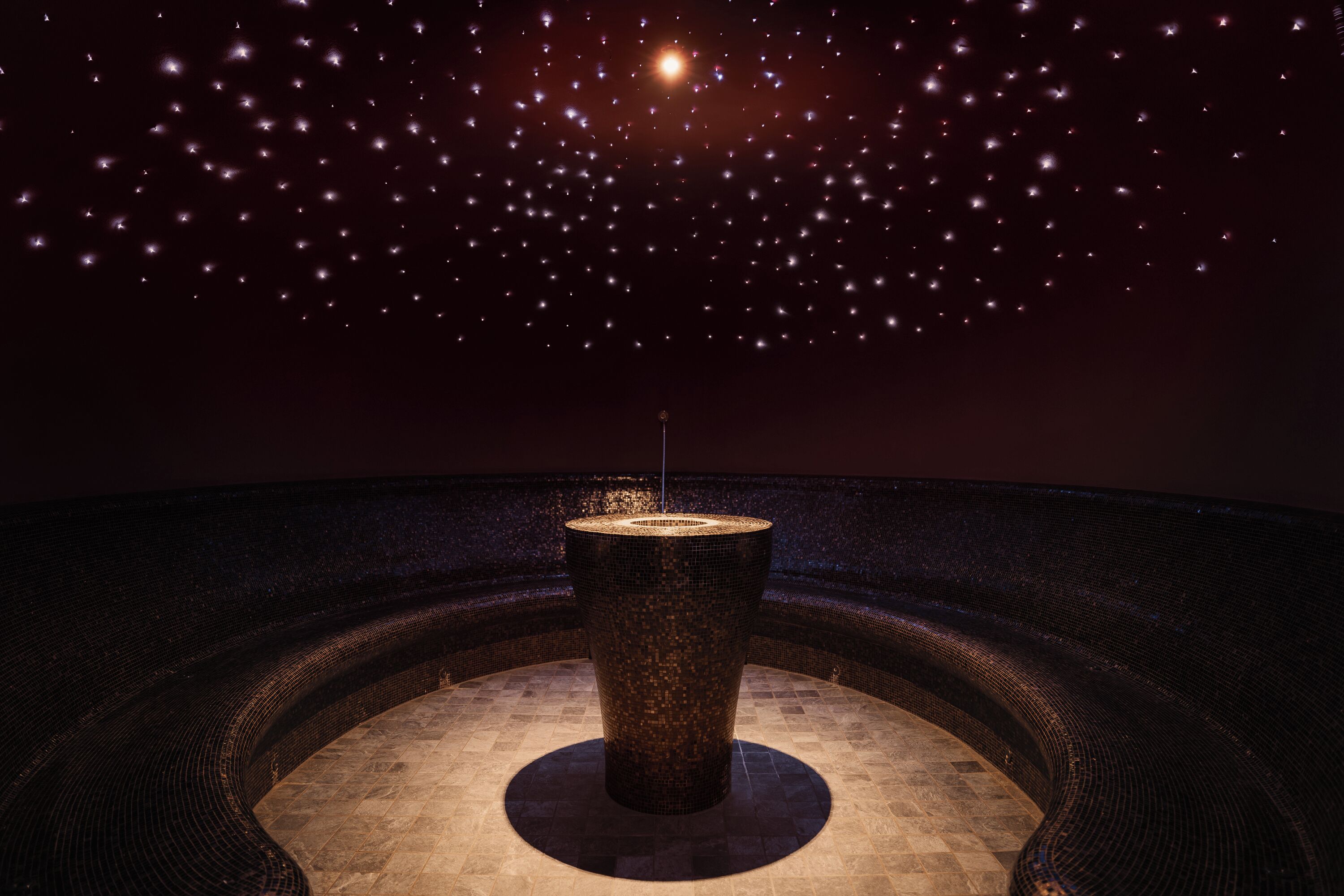 Una habitación circular con un pilar central y un techo estrellado.