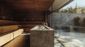 A modern bathroom with a stone sink, wooden slats, and a stone wall. - Hotel Granbaita Dolomites (Selva di Val Gardena)
