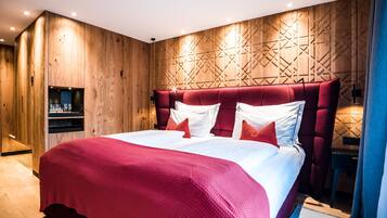 A modern bedroom with a large bed, wooden panel walls, and built-in shelves.