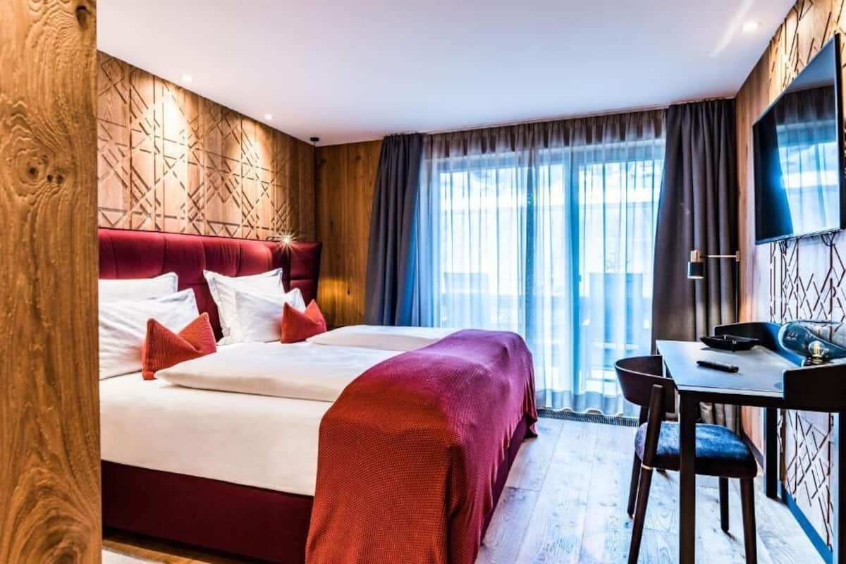 Une chambre d’hôtel avec un grand lit, un bureau et une télévision.