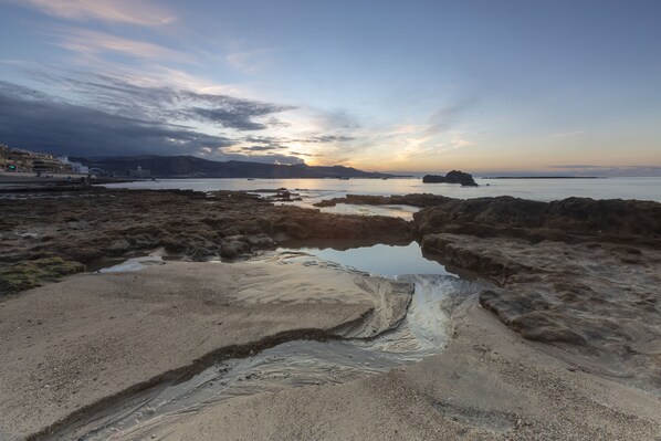 Un paisaje costero con terreno rocoso y aguas tranquilas.
