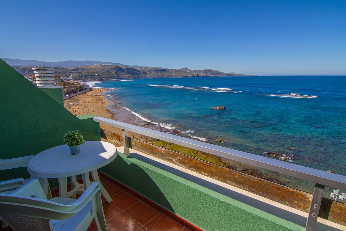 A balcony with a view of a beach and ocean.