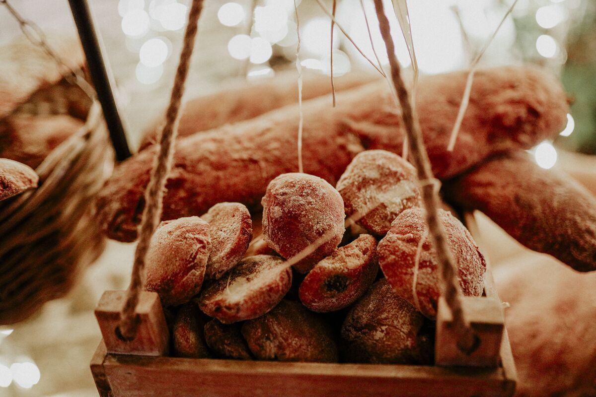 A wooden basket filled with pastries hanging from a string.