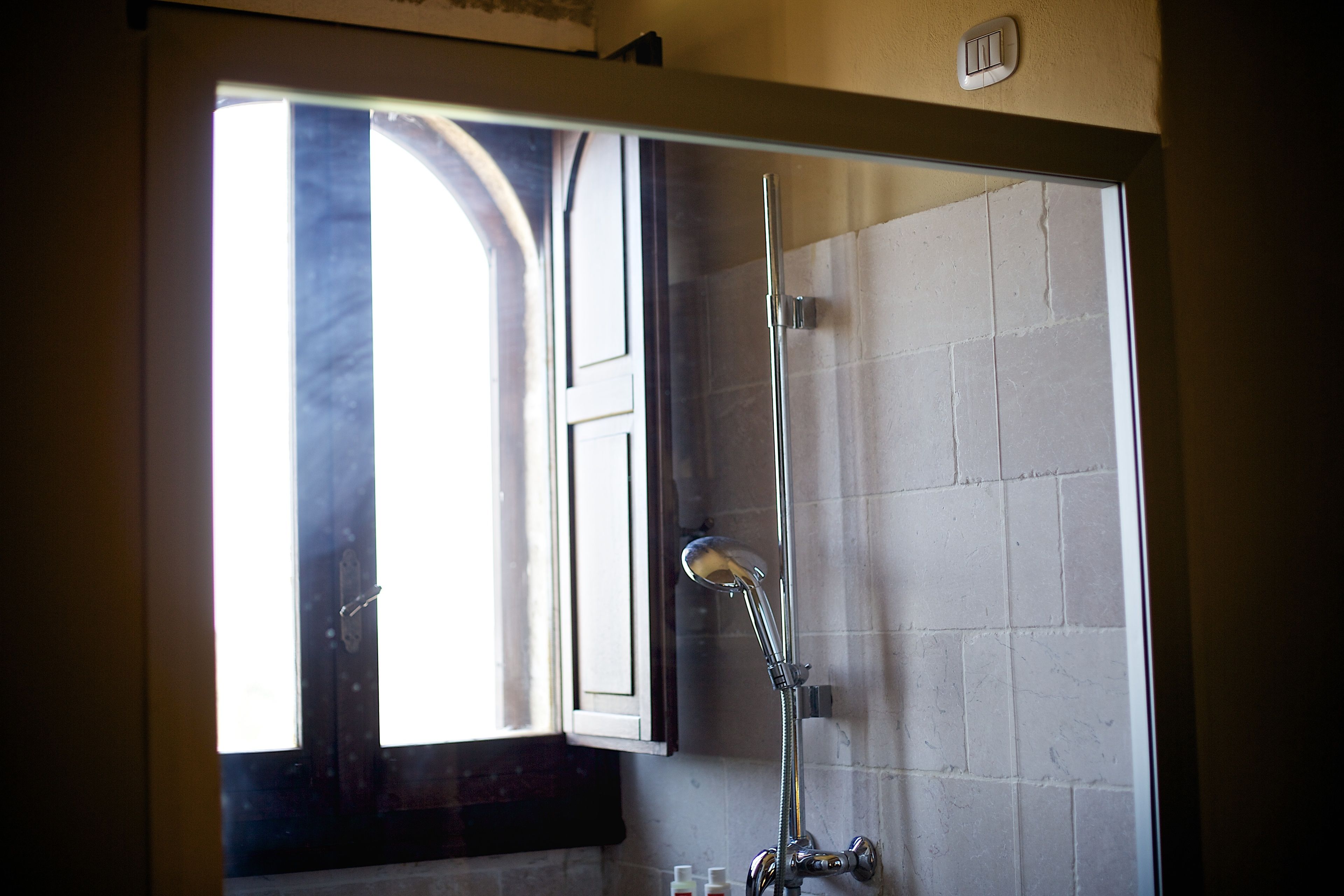 Une salle de bain avec une douche, une fenêtre et une porte.