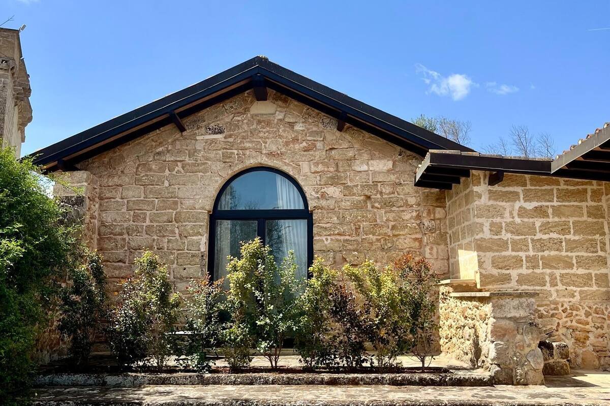 A stone building with a gabled roof and an arched window.