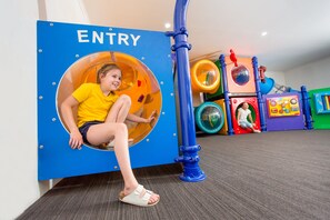 A child in a play tunnel with an 'ENTRY' sign, surrounded by colorful play structures. - BIG4 Melbourne Holiday Park (Coburg North)