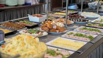 A buffet with various food items including meats, cheeses, and salads.