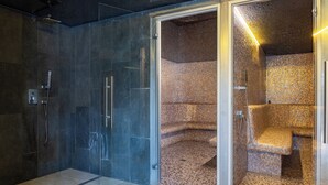 A modern bathroom with a glass shower enclosure, a tiled floor, and a mosaic wall. - Graal Spa (Swinoujscie)