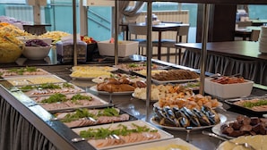 A buffet with various food items and a view of the dining area. - Graal Spa (Swinoujscie)