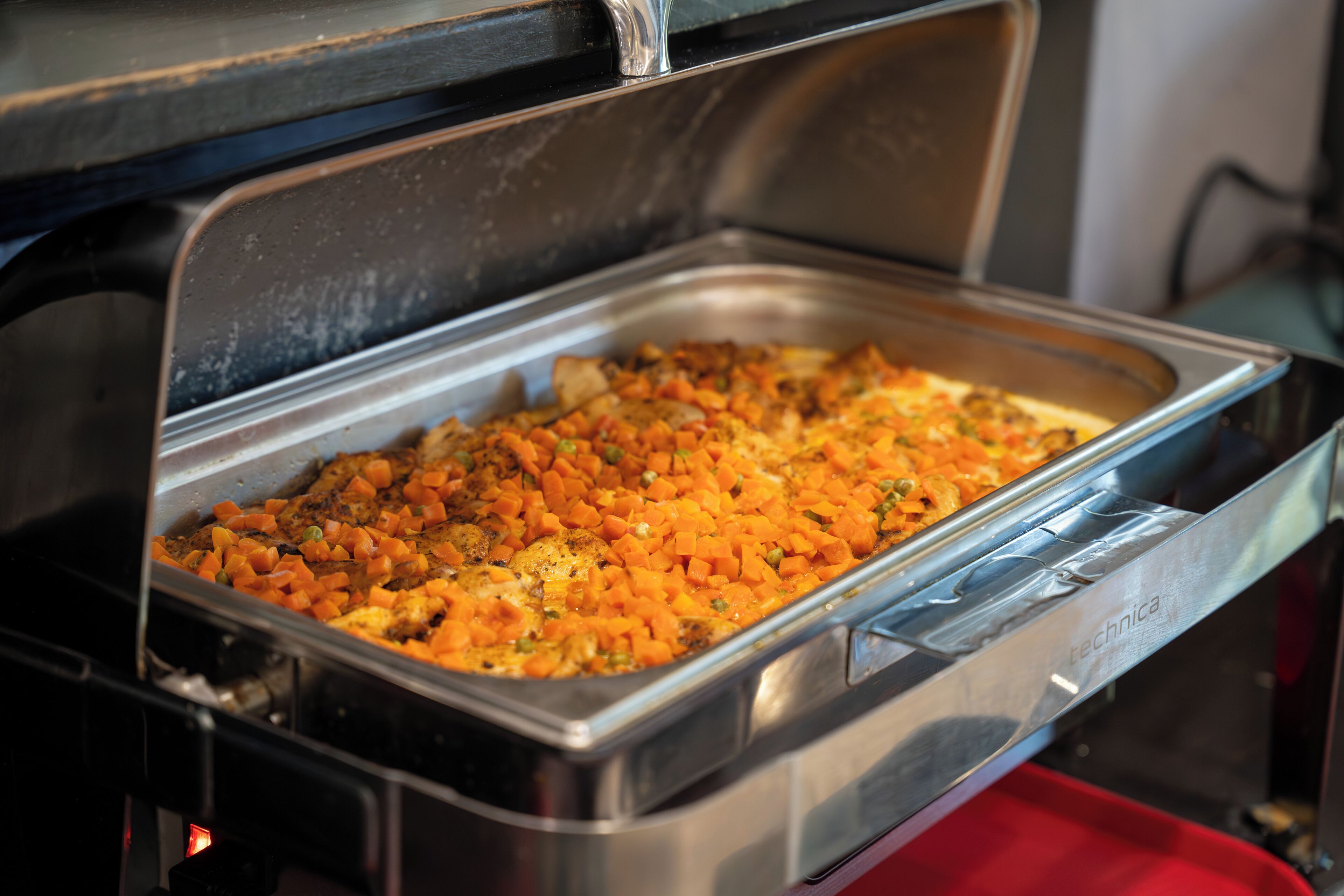 Ein Buffet mit verschiedenen Speisen, darunter eine Gemüseauflaufform und ein Gericht mit Fleisch.
