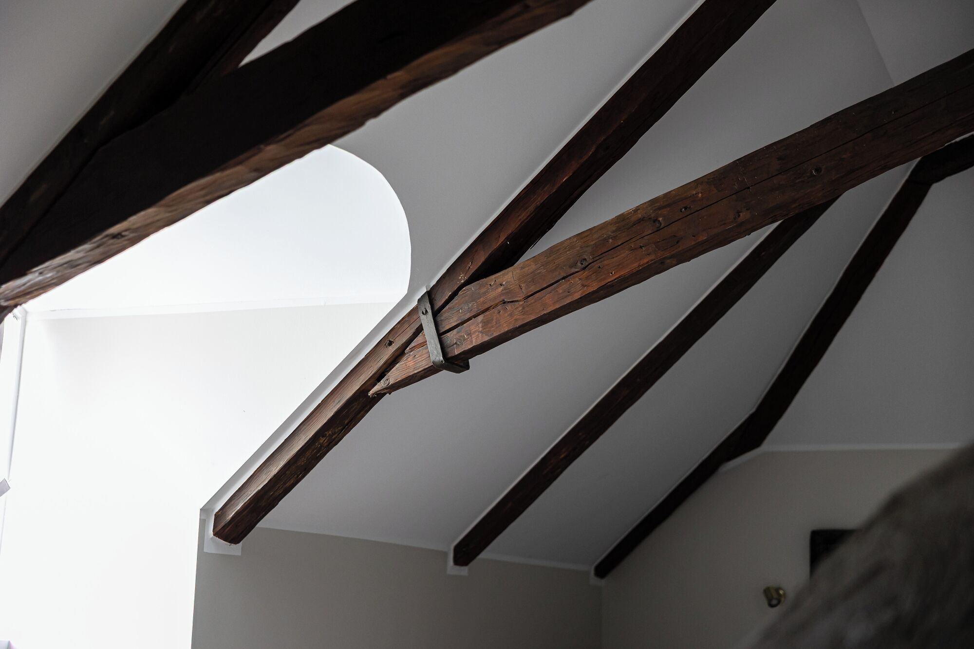 A room with exposed wooden beams and a skylight.