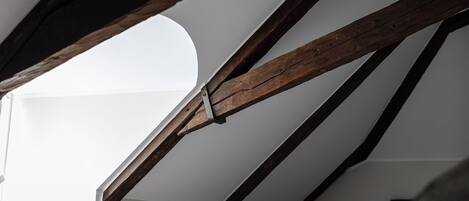 A room with exposed wooden beams and a skylight.