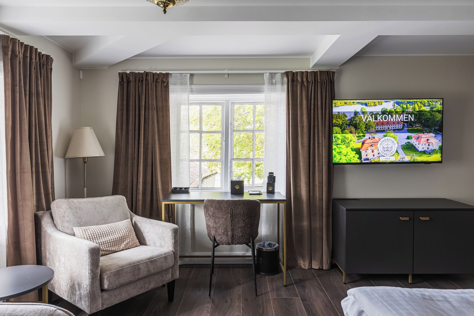 Une chambre d’hôtel comprenant un lit, un bureau, une chaise, une télévision et une armoire.