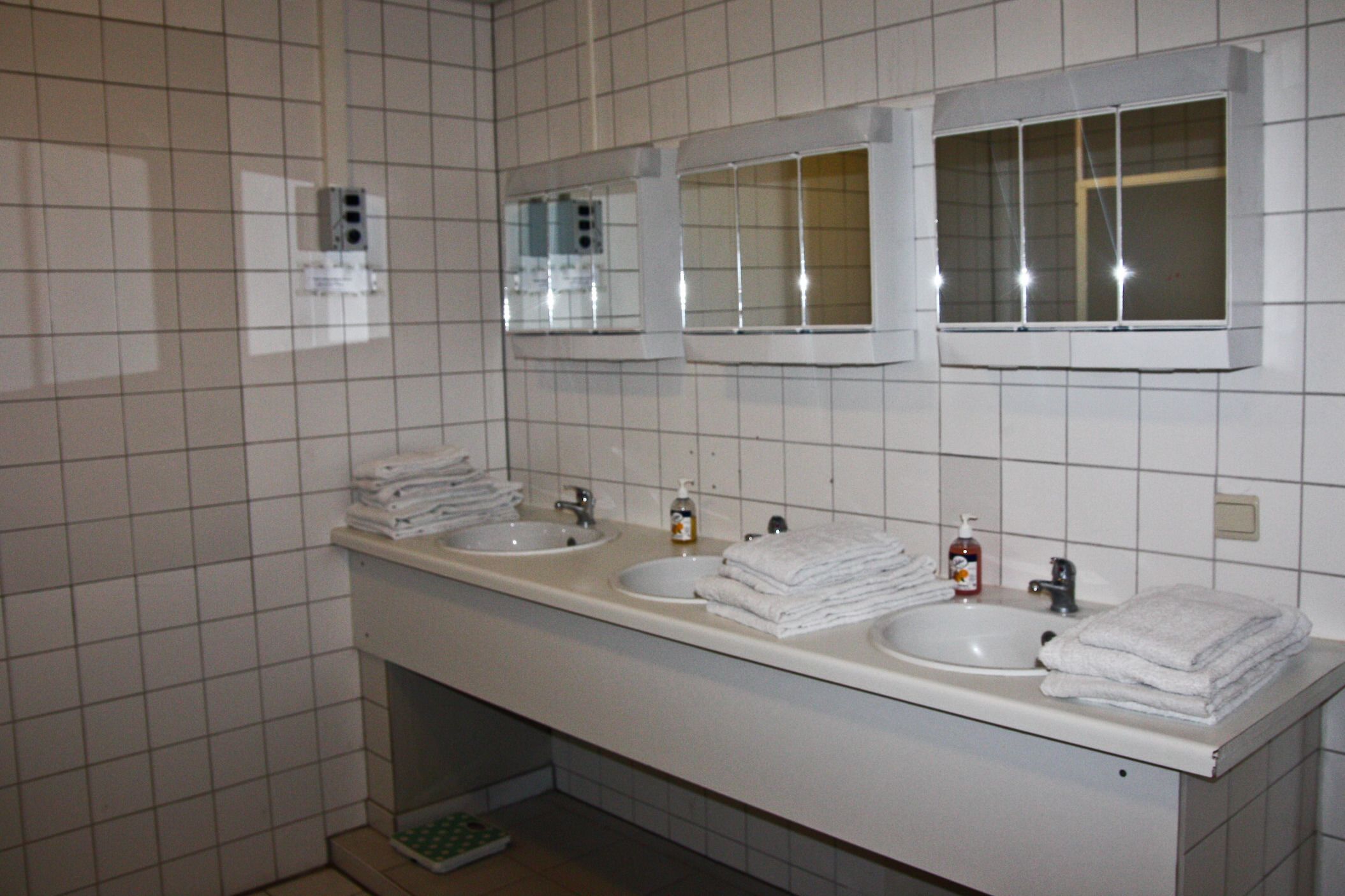 Casa de banho com duas pias, espelho e um porta-toalhas.
