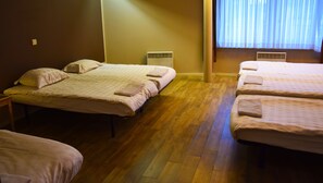 A hotel room with two single beds, a wooden floor, and a window with blinds. - Ambassador Suites Antwerp (Antwerp)