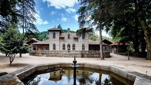 Un edificio storico in pietra con un cortile centrale e una fontana.