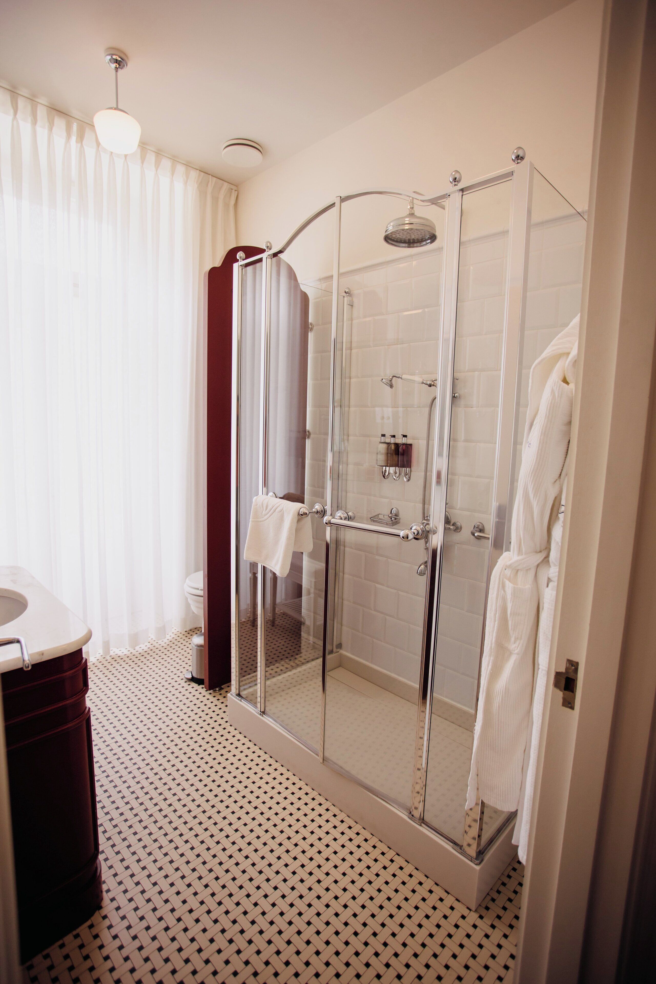 Un baño moderno con ducha de mampara de vidrio, inodoro y lavabo.