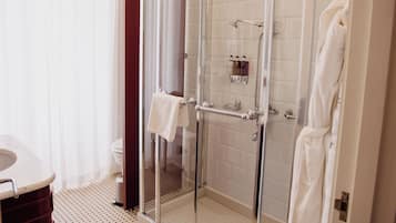 Un baño moderno con ducha de mampara de vidrio, inodoro y lavabo.