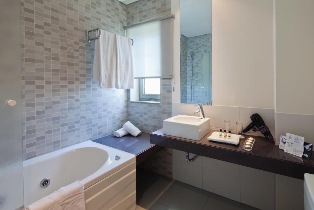 Een moderne badkamer met een bad, een wastafel en een spiegel.
