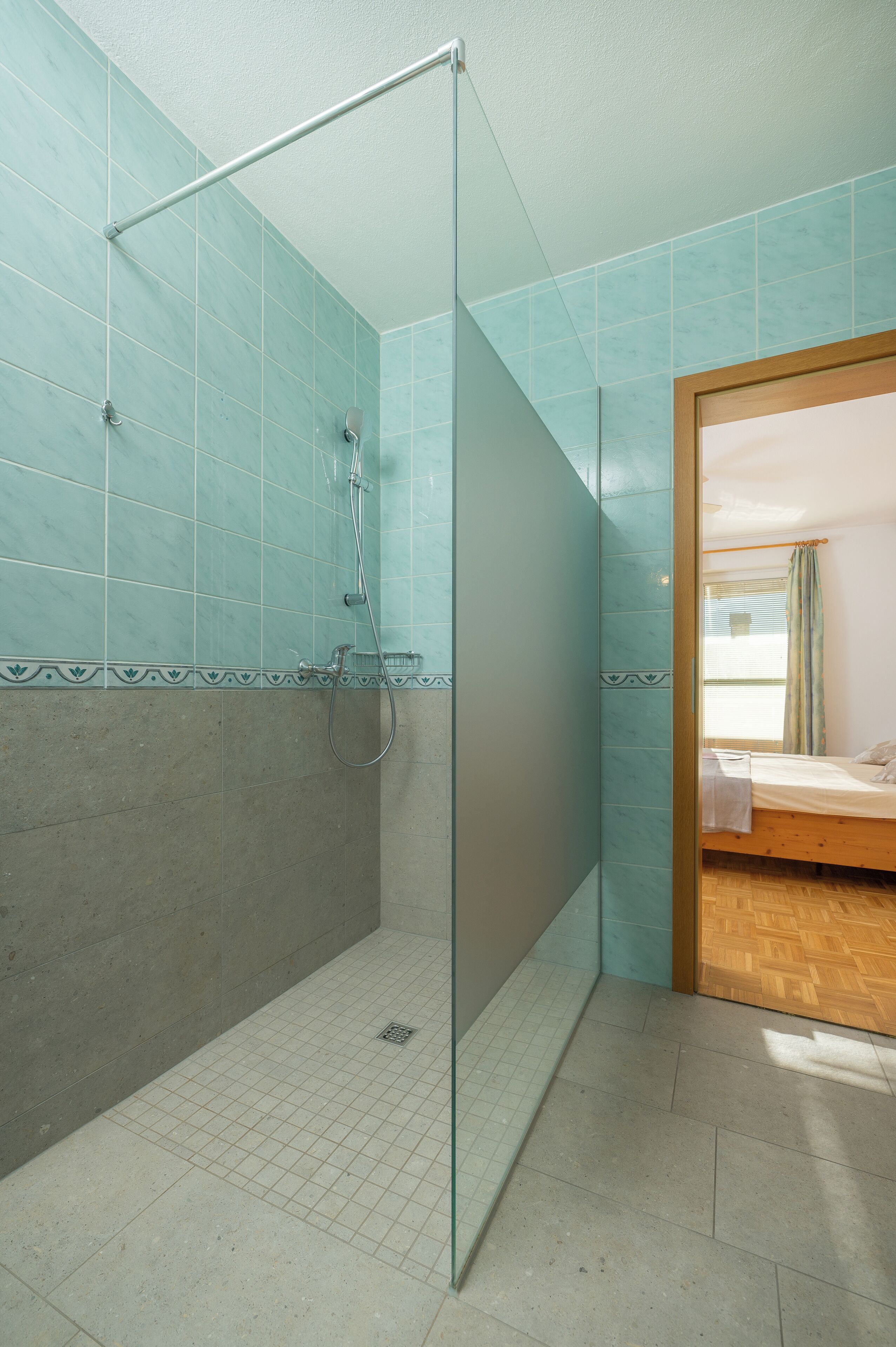 Un baño con cabina de ducha de vidrio, una bañera y piso de madera.