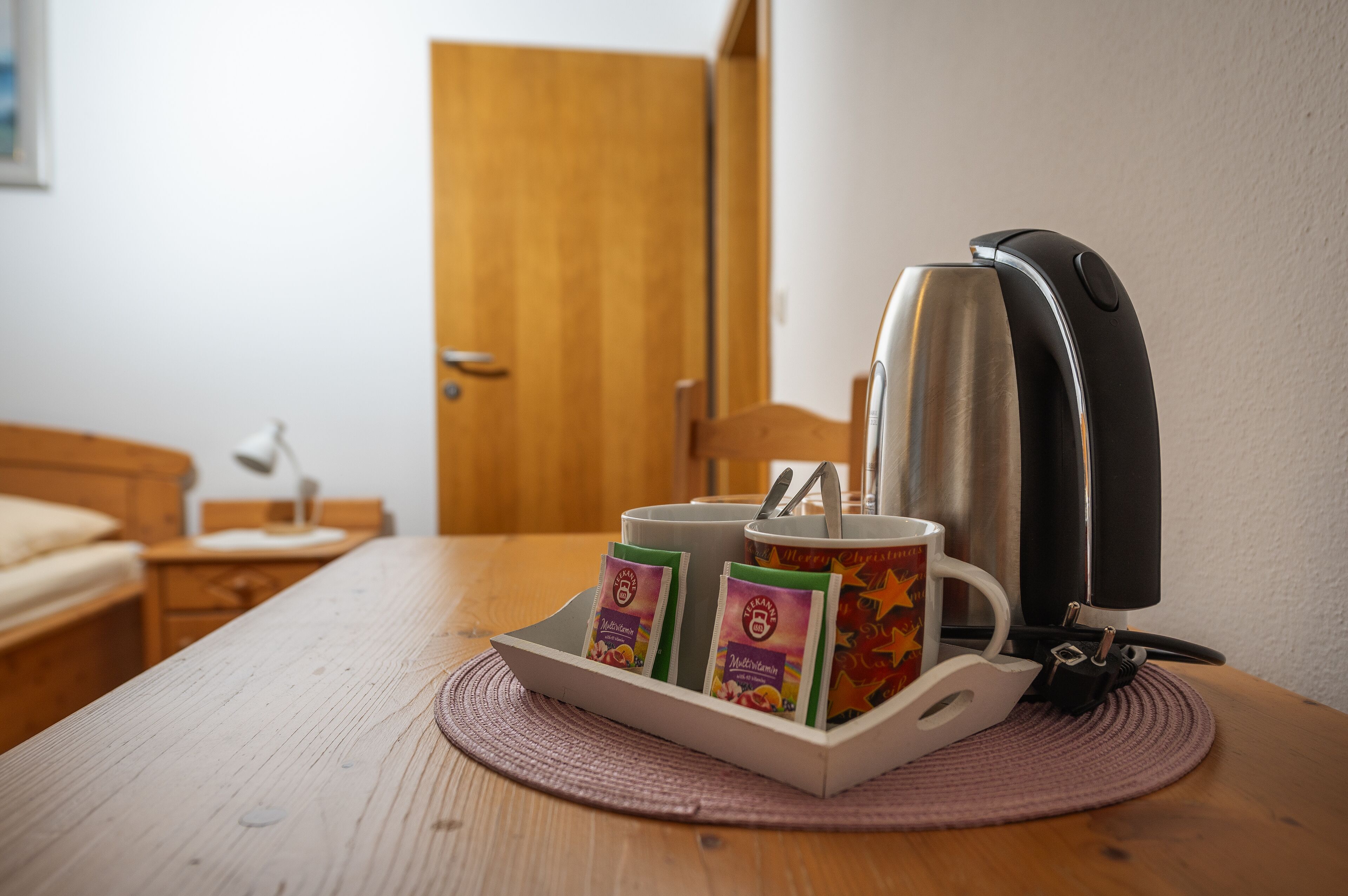 A coffee maker with a mug and two packets of coffee on a table.