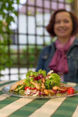Ein Tisch mit Salat und einer Person im Hintergrund.