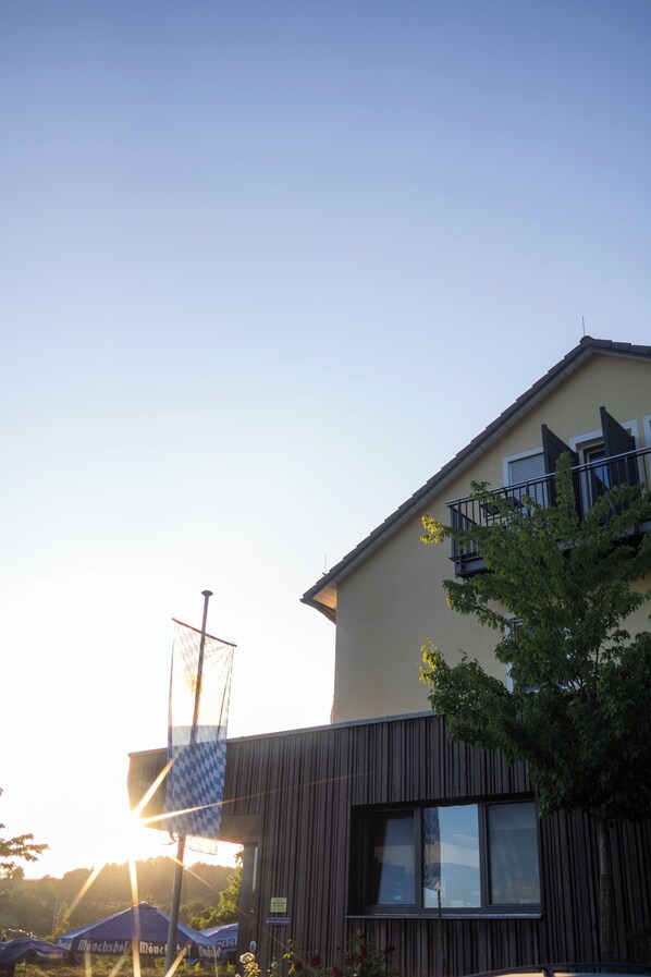 Un bâtiment moderne doté d’un toit en pente, de grandes fenêtres et d’un balcon.