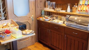 A buffet area with various food items, a coffee machine, and a fruit bowl. - Landgasthof Am Sonnenhang (Vohenstrauss)