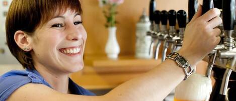 A person pouring beer from a tap into a glass.