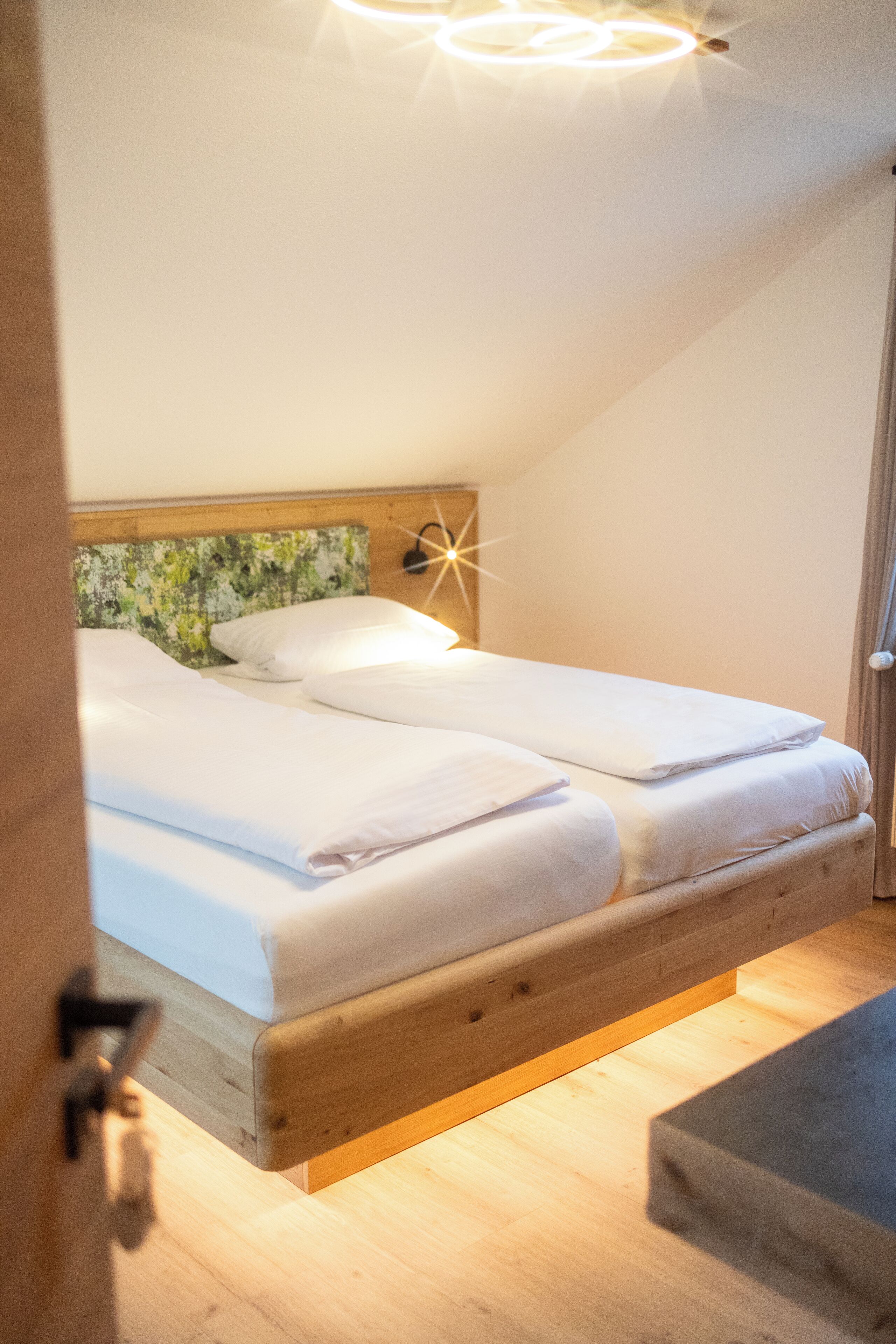 Ein Schlafzimmer mit einem hölzernen Kopfteil, einem Bett mit weißer Bettwäsche und einem Nachttisch mit einer Lampe.