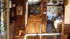Un interno in legno con zona pranzo, armadietti in legno e un orologio appeso al muro.