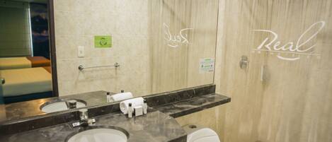 A modern bathroom with a marble sink, a toilet, and a shower curtain.