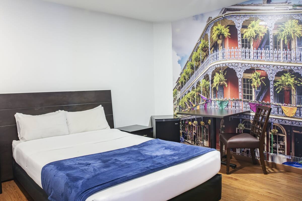 Una camera d'albergo con un letto, una scrivania e una sedia.
