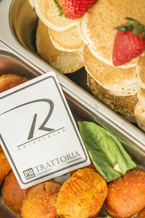 A buffet with various food items including pancakes, strawberries, and a sign indicating 'TRATTORIA' and 'Pii di Pasta'. - Hotel Santa Barbara Real (Bogotá)