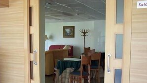 A room with a dining table, chairs, and a sofa. - Hotel Estrella del Alemar (Ribamontan al Mar)