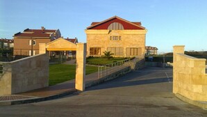A hotel entrance with a stone pathway leading to a gated driveway. - Hotel Estrella del Alemar (Ribamontan al Mar)