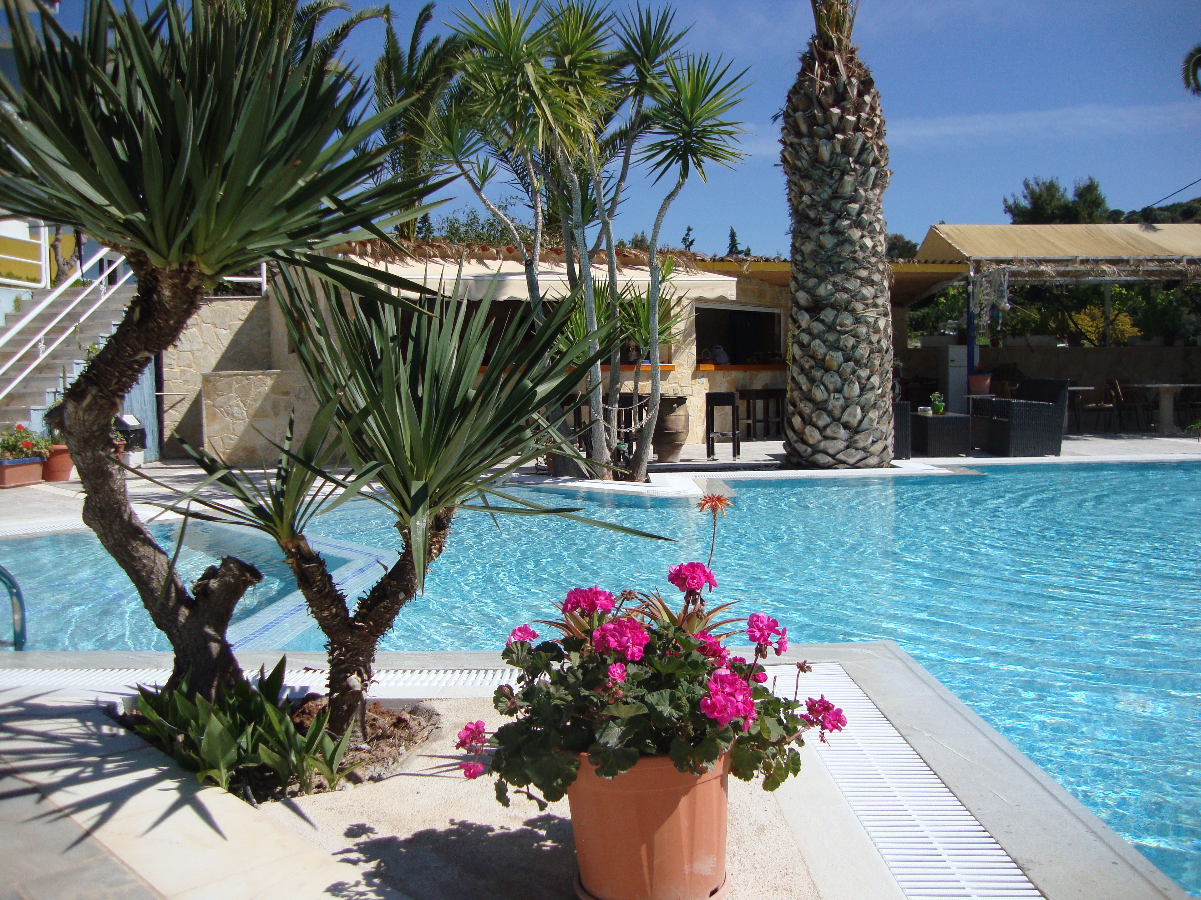 Una piscina al aire libre de temporada, sombrillas