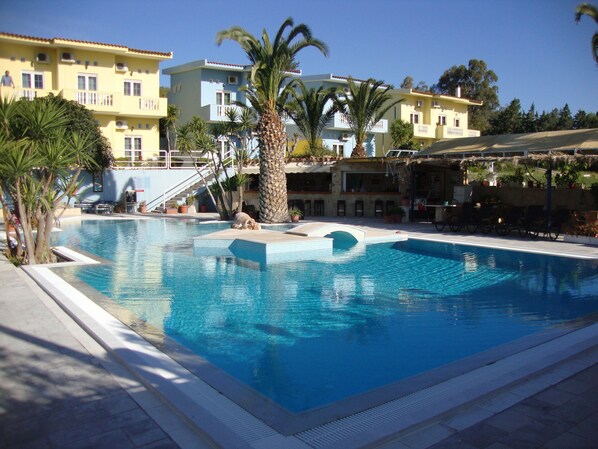 A swimming pool with a palm tree and a staircase leading to a building.