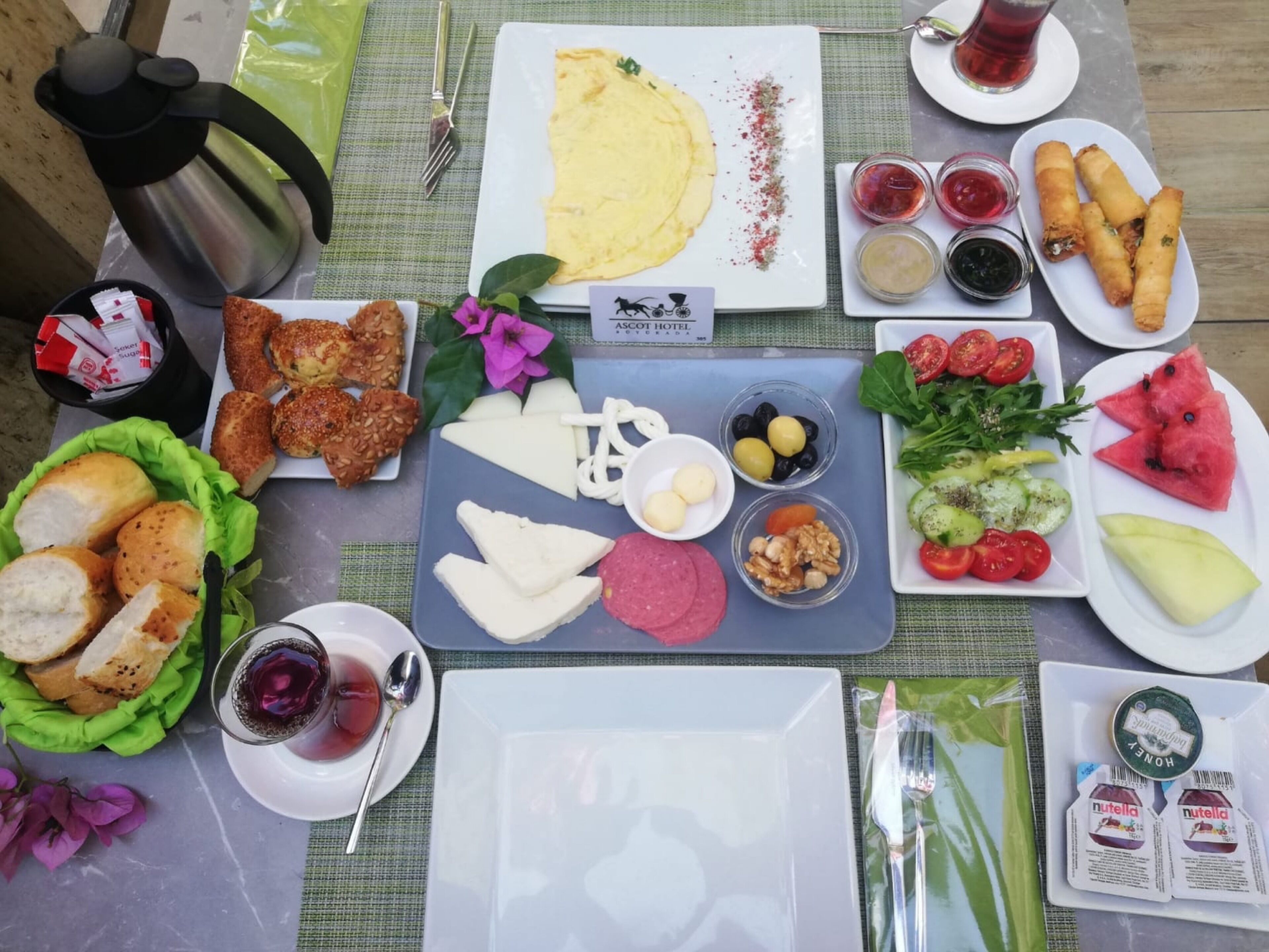 A table with various food items including bread, eggs, olives, and a salad.