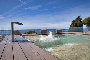 A pool area with clear water, a wooden deck, and lounge chairs. - Hotel Le Roi (Varazze)