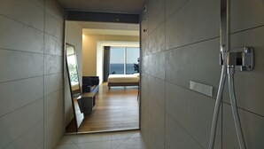 A modern hotel room with a large bed, a desk, and a view of the sea. - Hotel Le Roi (Varazze)
