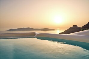 A pool with clear blue water and a sunset view. - Mirabo Luxury Villas (Santorini)
